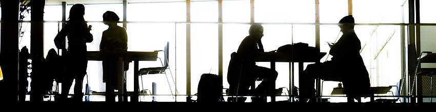 Grey silhouettes of people against a bright window