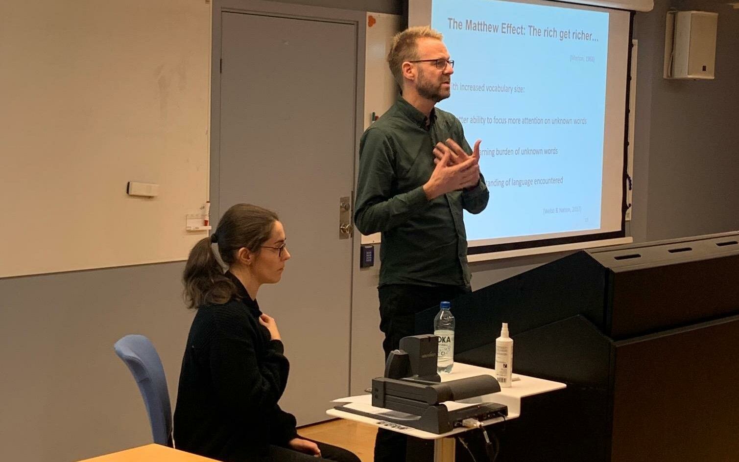 Elin Nylander and Henrik Gyllstad speaking in front of a PowerPoint screen.