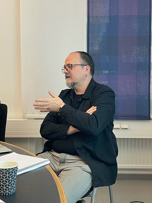 Alexander Bareis sitting down discussing with the audience