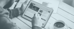 A black and white photo of hands holding a tablet.