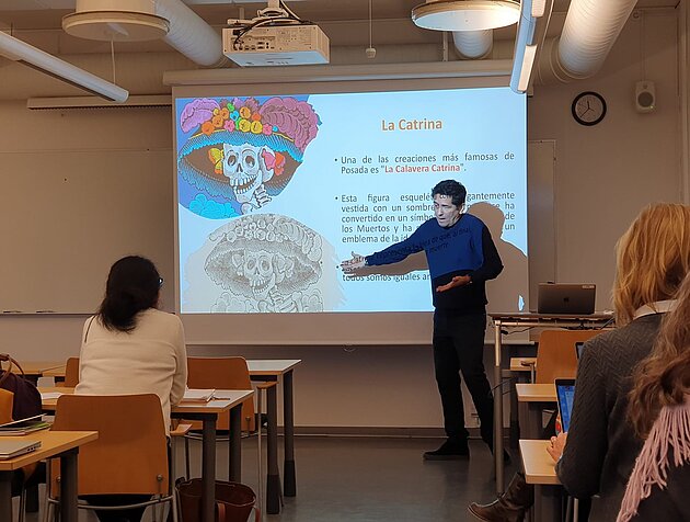 Antonio Vasquez in front of a colourful PowerPoint slide about La Catrina